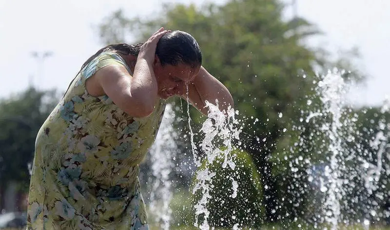 Una mujer se refresca en una de las fuentes de la ciudad debido a las altas temperaturas que se registran en C&oacute;rdoba, dentro de la ola de calor que se registra en casi toda Espa&ntilde;a